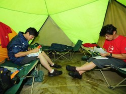 Katsumi Hamura and Hiroyuki Sugiura study their road books in the tent.