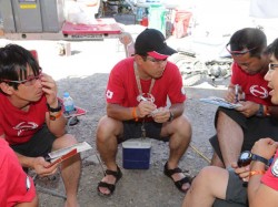 Mechanics go over servicing procedures before the HINO500 Series racing trucks arrive.