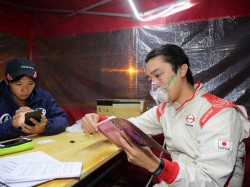 Teruhito Sugawara checks the roadmap for the following day with his oxygen mask on. 