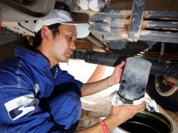 Mechanic Shunsuke Sugawara replaces an oil filter. 